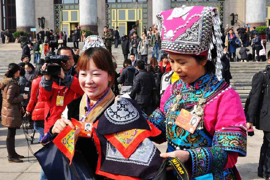 云南代表團的兩位女代表在為記者展示她們帶來的民族特色手工藝品,。 人民網(wǎng)記者 馬麗婭 攝