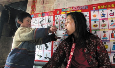 小孫悅為臥床的母親喂飯,。